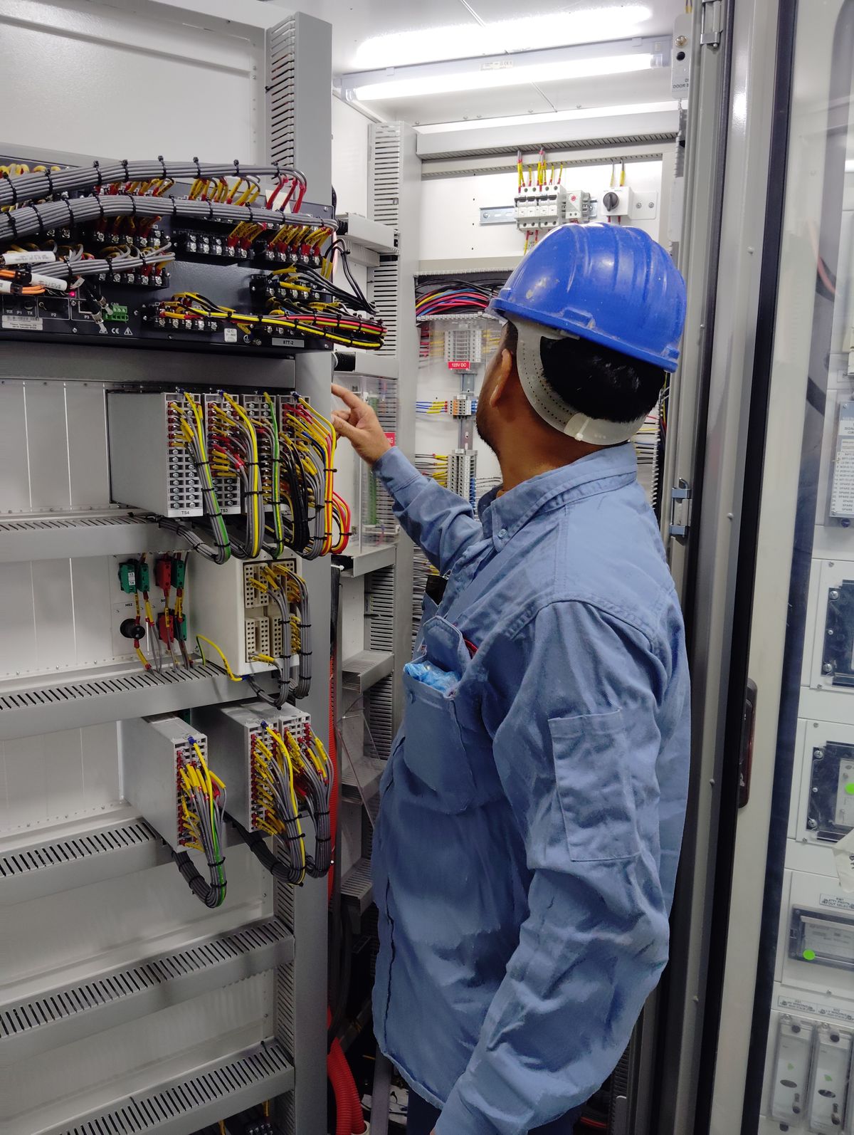Technician commissioning a protection panel on site